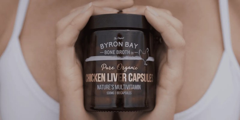 Hands holding a jar of Byron Bay Bone Broth organic chicken liver capsules