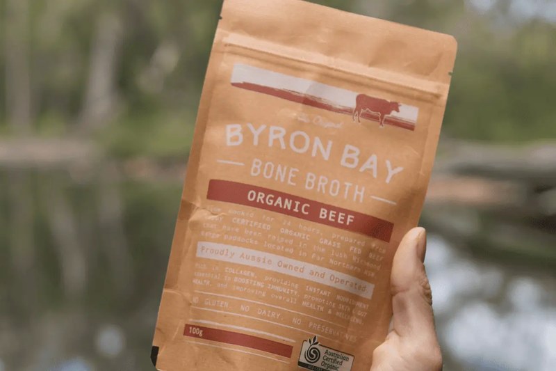 A pouch of organic beef bone broth beside a creek