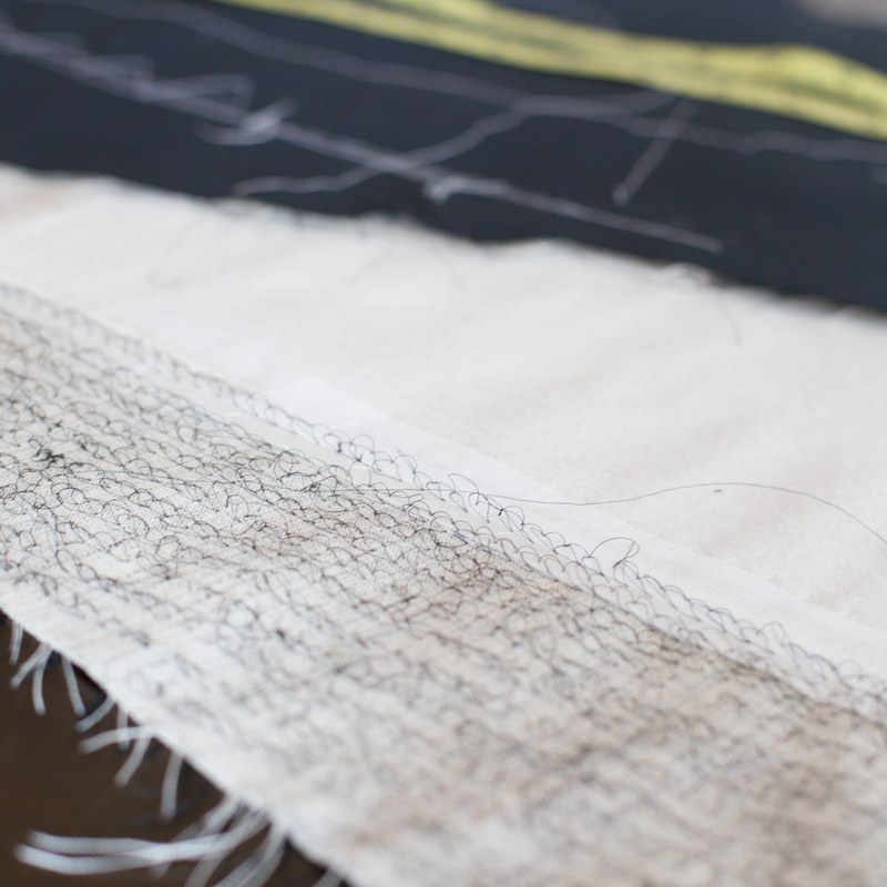 Hand-stitched canvas and chalk marks on navy cloth