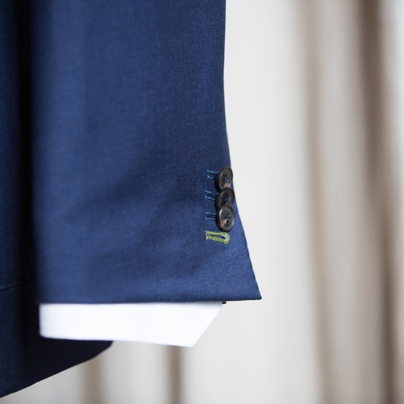 A navy jacket cuff with working buttons