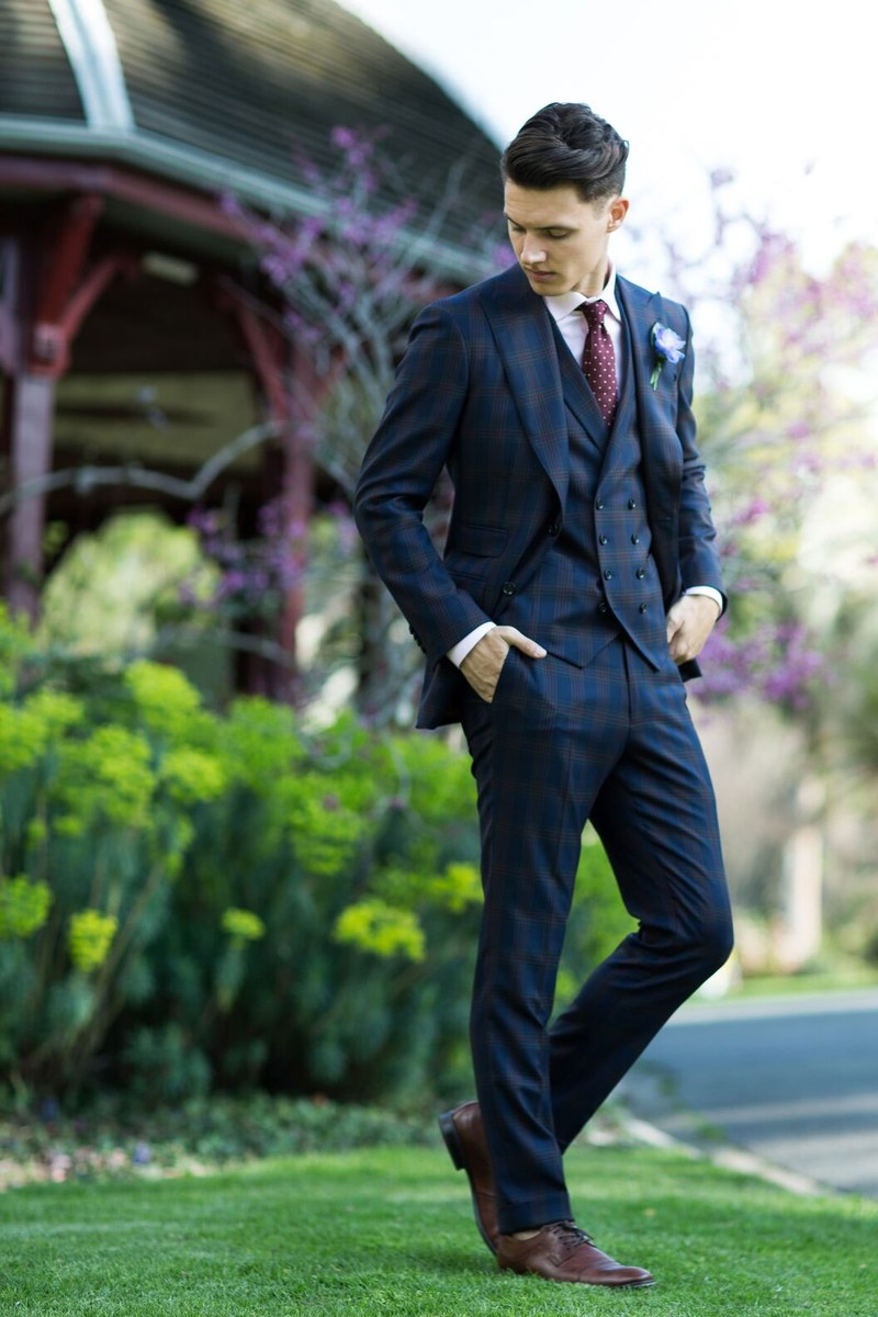The same navy suit, walking through a Melbourne garden