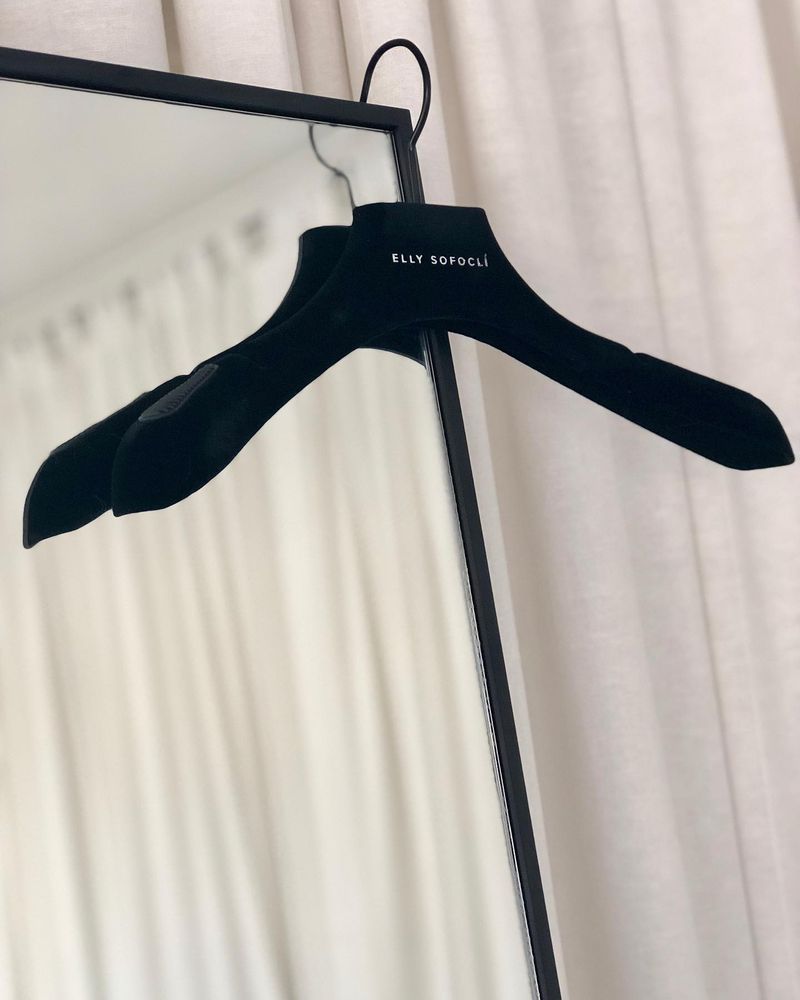 A black velvet hanger carrying the Elly Sofoclí wordmark