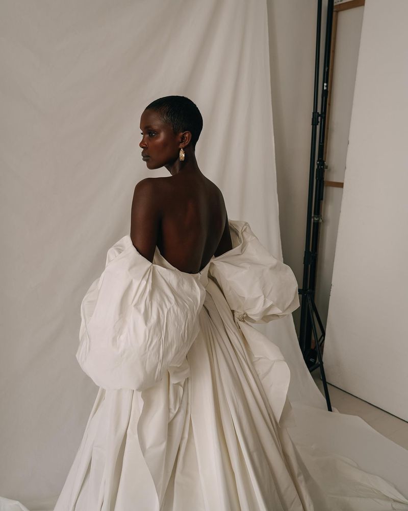 Model in a strapless Elly Sofoclí gown with sculpted sleeves, seen from behind