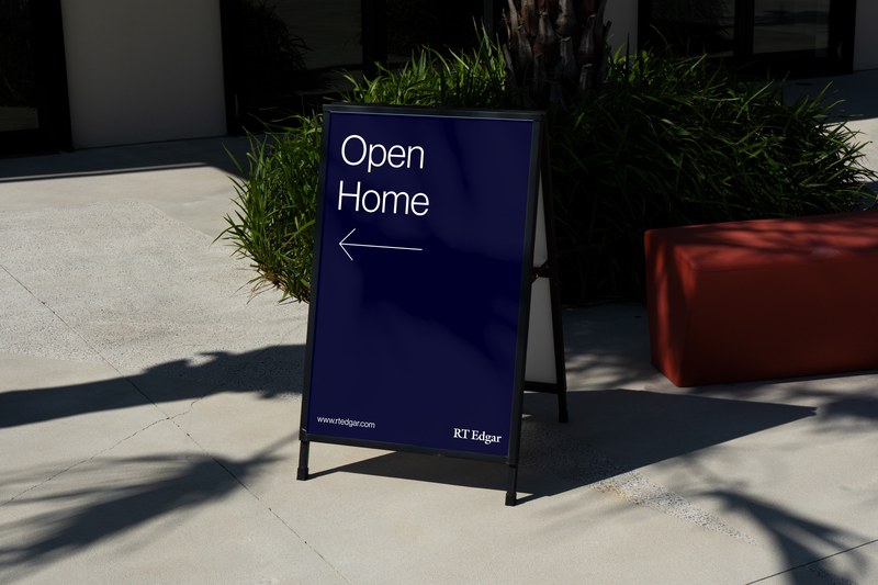 A navy RT Edgar open home A-frame on a footpath